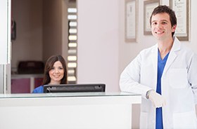 Dentist and dental team member at front desk