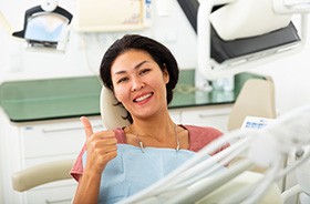 Happy dental patient making thumbs-up gesture