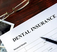 Dental insurance paperwork with pen and glasses