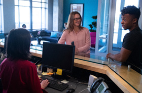 Dental team member helping patients at front desk