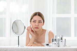 Concerned woman looking at herself in mirror