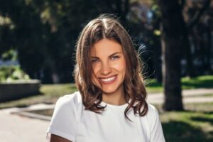 Smiling, confident young woman standing outdoors